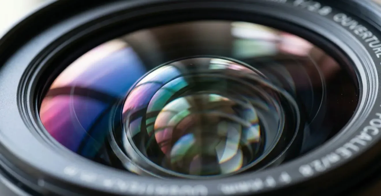 Gros plan extrême sur des éléments de verre d'un objectif professionnel avec reflets lumineux sur les traitements antireflet